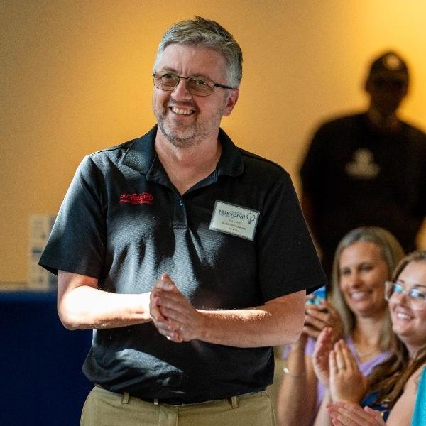 Michael Gerstweiler, owner of Pribusin Inc., reacts near his family, (from left) Nick Gerstweiler, Jessica Gerstweiler and wife, Sue Gerstweiler, after winning the 2024 Lakeshore Innovator of the Year award at the Muskegon Innovation Hub on July 25.